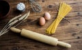 Spaghetti and flour and eggs with kitchenware on wooden background Royalty Free Stock Photo