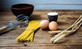 Spaghetti and flour and eggs with kitchenware on wooden background Royalty Free Stock Photo