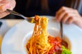 Spaghetti on a fork. Girl use fork with spaghetti. Pasta with red sauce Royalty Free Stock Photo