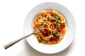 Spaghetti with fork, tomato sauce, fresh basil and cheese. Isolated on white from above.