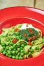 Spaghetti with fresh green peas. Gray textured background with beige fabric. Beautiful serving of dishes. Restaurant Royalty Free Stock Photo