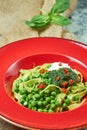 Spaghetti with fresh green peas. Gray textured background with beige fabric. Beautiful serving of dishes. Restaurant Royalty Free Stock Photo