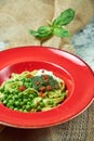 Spaghetti with fresh green peas. Gray textured background with beige fabric. Beautiful serving of dishes. Restaurant Royalty Free Stock Photo