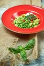 Spaghetti with fresh green peas. Gray textured background with beige fabric. Beautiful serving of dishes. Restaurant Royalty Free Stock Photo