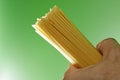 Spaghetti in humand hand on green background Royalty Free Stock Photo