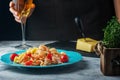 Spaghetti, Mafaldin with tomato sauce, shrimp, cherry tomatoes and thyme. Cropped photo of a girl with a glass of wine