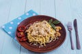 Spaghetti with mushrooms in cream sauce on a blue wooden background. Royalty Free Stock Photo