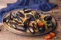 Spaghetti with mussels, tomatoes in spicy sauce in the original plate on the old wooden table. Clams Mytilus closeup. Royalty Free Stock Photo