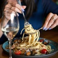 Spaghetti with mussels. Woman winds on fork seafood and Italian pasta. Close up shot. Healthy exotic lunch. Soft focus