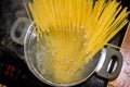 Spaghetti noodles cooking in casserole on ceramic hob with steam horizontal Royalty Free Stock Photo