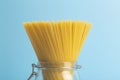 Spaghetti pasta on a blank blue background. Raw fresh isolated spaghetti in a jar before preparing italian food Royalty Free Stock Photo