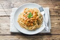 Spaghetti pasta Bolognese on white plate, wooden table Royalty Free Stock Photo