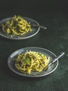 Spaghetti pasta bucatini with pesto sauce and parmesan. Italian traditional perciatelli pasta by genovese pesto sauce in two gray