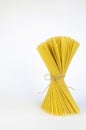 Spaghetti pasta, a bundle of pasta tied with linen thread. The concept of pasta. Royalty Free Stock Photo