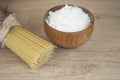 Spaghetti pasta with flour in wood bowi on wooden table Royalty Free Stock Photo