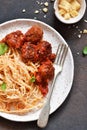 Spaghetti pasta with meatballs, tomato sauce and parmesan on the kitchen table. View from above