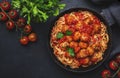 Spaghetti pasta with meatballs in tomato sauce with parsley in frying pan, dark table background, top view Royalty Free Stock Photo