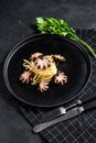 Spaghetti pasta with mini grilled octopus. Black background. Top view