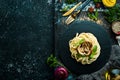 Spaghetti pasta with mushrooms and basil in a black stone plate. Italian food. Top view.