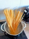 Spaghetti pasta shiny pot saucepan with water on the black cooker ready to cook. Home dinner cooking Royalty Free Stock Photo