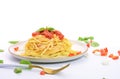 Spaghetti or pasta with tomato sauce and fresh green basil on a white plate with tomato isolated fork on a white background - top Royalty Free Stock Photo