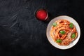 Spaghetti pasta with tomato sauce, Parmesan cheese and fresh basil leaves, shot from the top on a black background Royalty Free Stock Photo