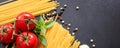 Spaghetti pasta, tomatoes, garlic and basil on black background, banner Royalty Free Stock Photo