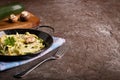 Pan of spaghetti prepared from zucchini and mushroom sauce on wooden table Royalty Free Stock Photo