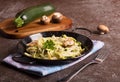 Pan of spaghetti prepared from zucchini and mushroom sauce on wooden table Royalty Free Stock Photo
