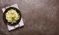 Pan of spaghetti prepared from zucchini and mushroom sauce on wooden table Royalty Free Stock Photo