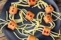 spaghetti with sausages in the form of spiders. Happy kid food for Halloween party. Top view Royalty Free Stock Photo