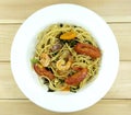 Spaghetti seafood in a dish on a white wood floor table.