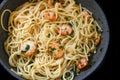 Spaghetti with shrimps parsley and garlic in a cooking pan for a Mediterranean seafood meal Royalty Free Stock Photo