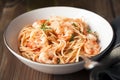 Spaghetti with shrimps, tomato sauce and chopped parsley.