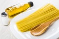 Spaghetti, spoon in dish, salt, vegetable oil in bottle