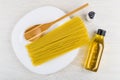 Spaghetti, spoon in dish, salt, vegetable oil on wooden table Royalty Free Stock Photo