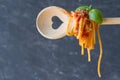 Spaghetti on spoon with heart, dark background, love italian food concept Royalty Free Stock Photo