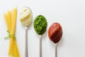 Spaghetti and three spoons with different condiments Royalty Free Stock Photo