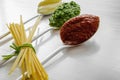 Spaghetti and three spoons with different condiments Royalty Free Stock Photo