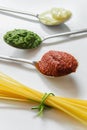 Spaghetti and three spoons with different condiments Royalty Free Stock Photo