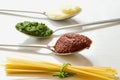 Spaghetti and three spoons with different condiments Royalty Free Stock Photo