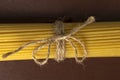 Spaghetti tied with twine on a brown background. kitchen theme