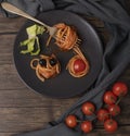 Spaghetti with tomato sauce is rolled on a fork on a dark plate with cherry tomatoes next to it Royalty Free Stock Photo