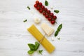 Spaghetti, tomatoes, basil, parmesan, garlic. Ingredients for cooking italian pasta on a white wooden table, flat lay. Royalty Free Stock Photo