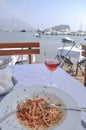 Spaghetti and wine glass on table by sea Royalty Free Stock Photo