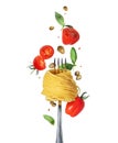 Spaghetti wrapped around fork with flying tomatoes, basil leaves and capers close-up isolated on a white background Royalty Free Stock Photo