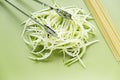 Spaghetti and zucchini on green chopping board Royalty Free Stock Photo