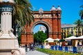 Spain, Barcelona - May 30 2022: Promenade Passeig de LluÃÂ­s Companys in front of the Arc de Triomf. People walk and cyclo rickshaw
