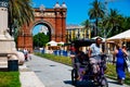 Spain, Barcelona - May 30 2022: Promenade Passeig de LluÃÂ­s Companys in front of the Arc de Triomf. People walk and cyclo rickshaw