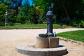Spain, Barcelona - May 30 2022: Small, metal fountain-column with free drinking water in the Ciutadella Park